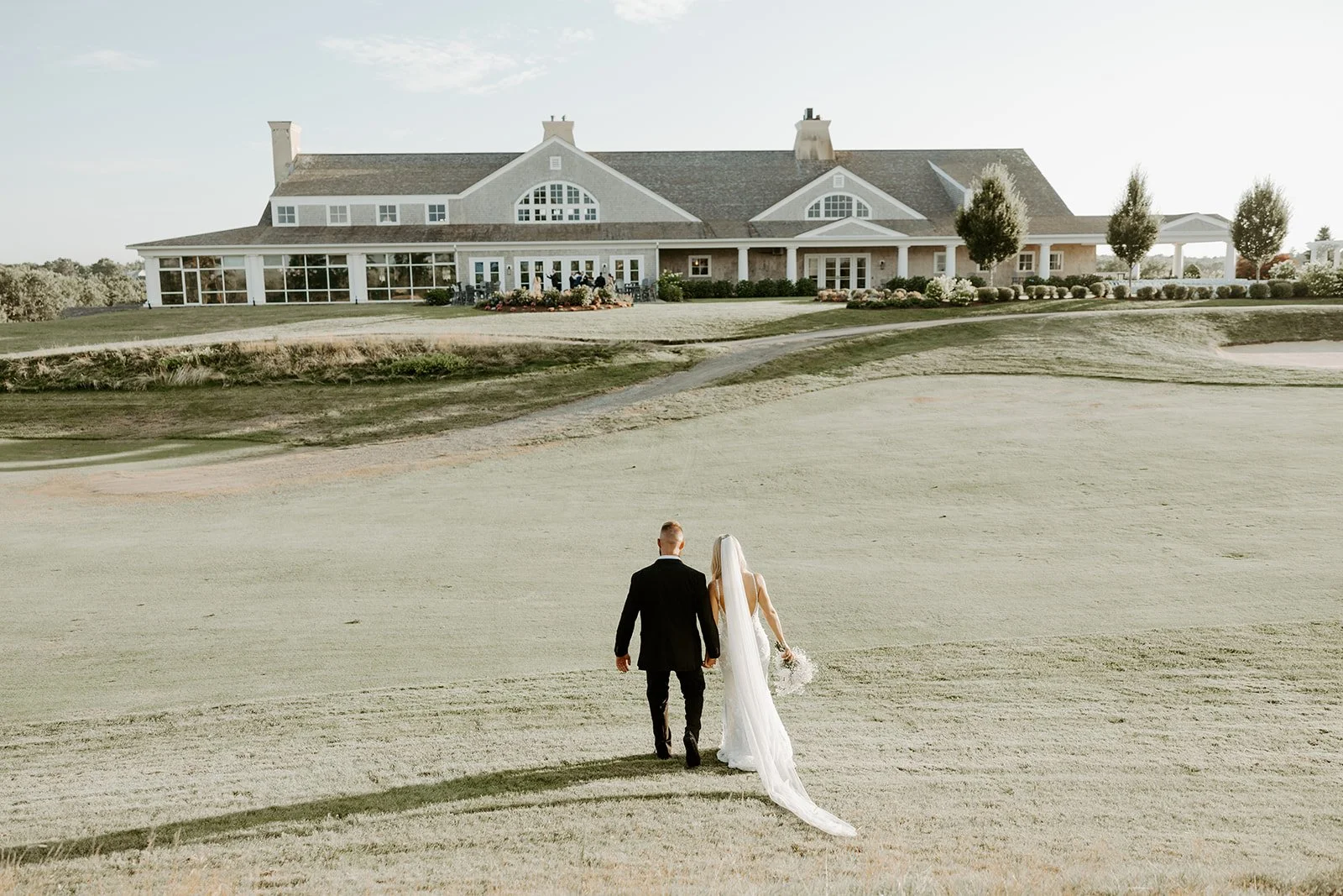 A bride and groom walking across the golf course at waverly oaks
