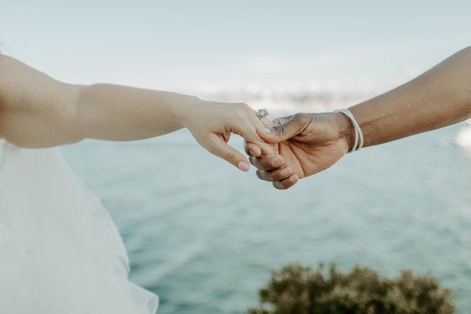 Two brides holding hands at their wedding