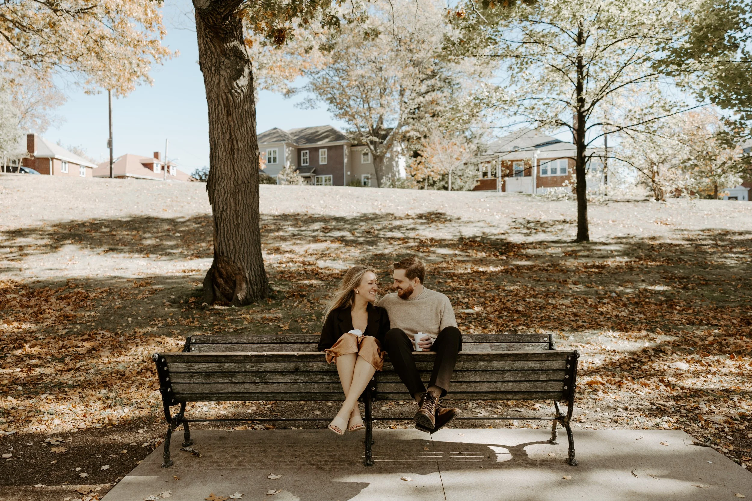 A couple sitting on a bench during their engagement photoshoot, captured by a Boston engagement photographer