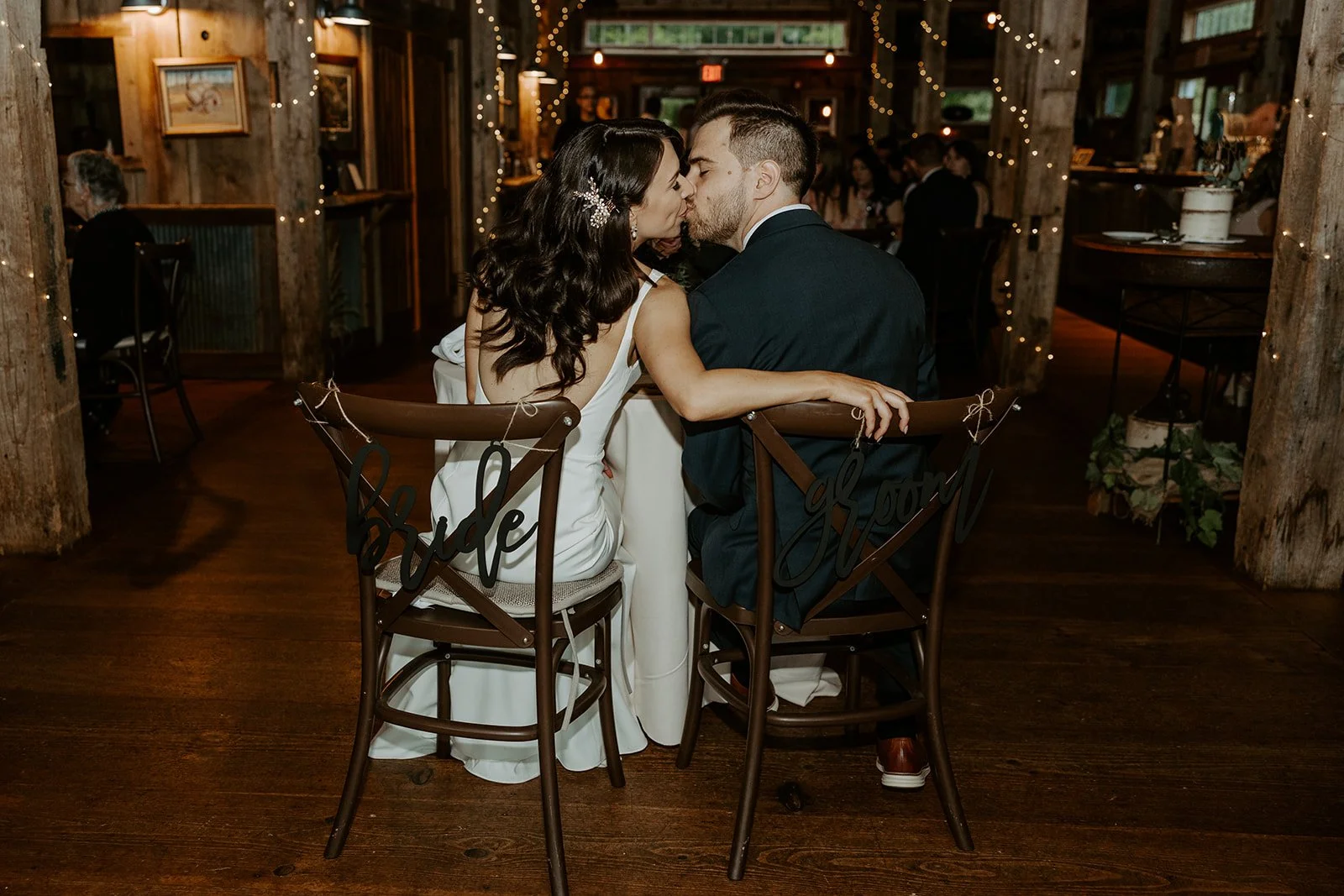 A bride and groom kissing in candid wedding photos from their wedding reception