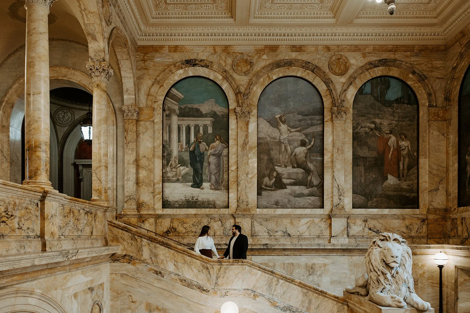 A couple posing for engagement photos in the Boston public library
