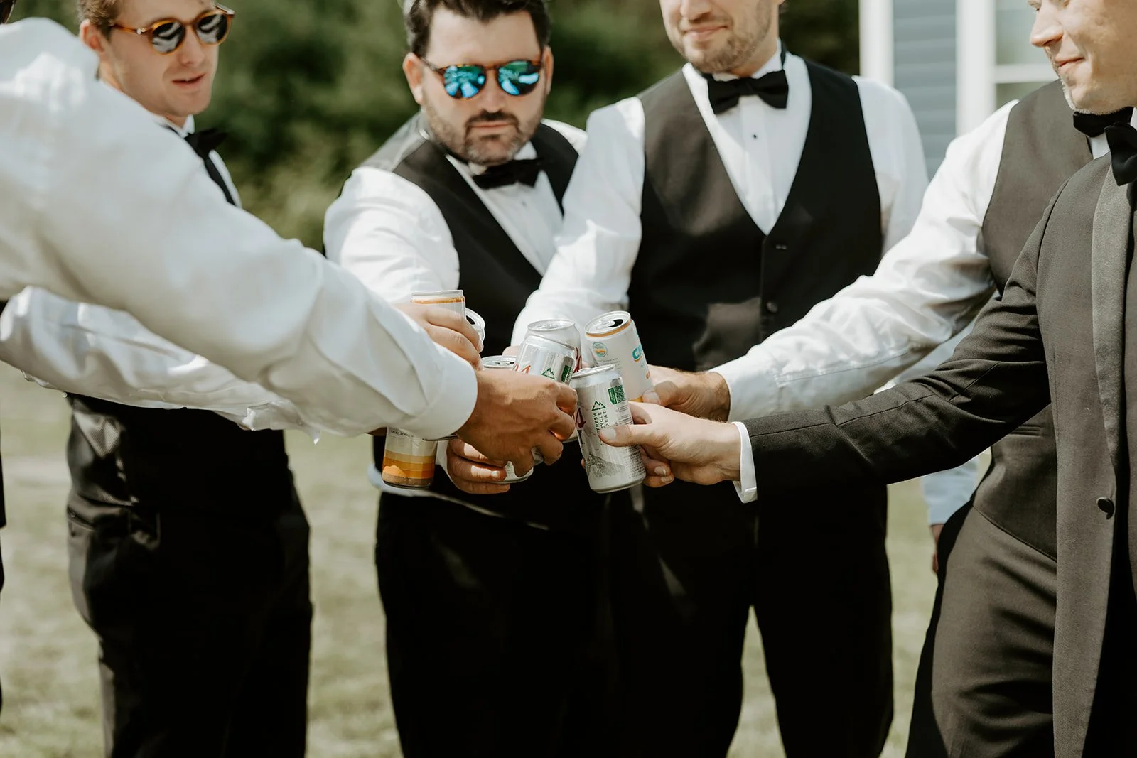 Groomsmen clinking beer cans