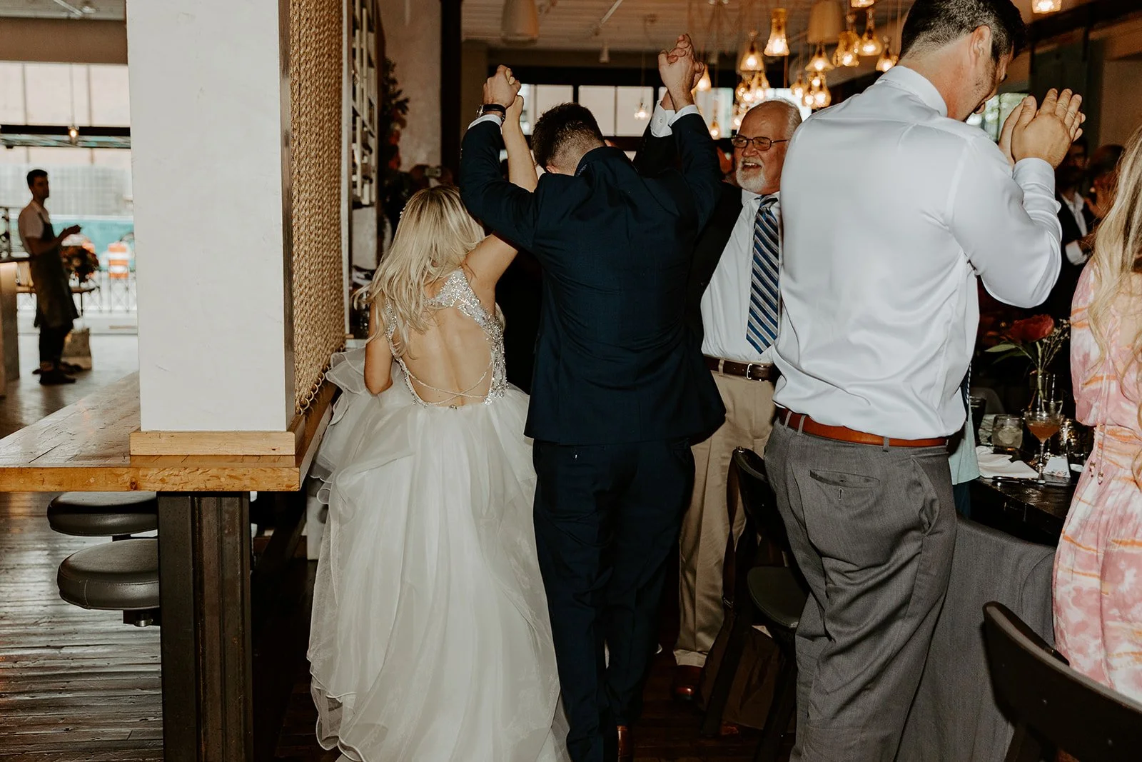 A bride and groom walking through their restaurant wedding