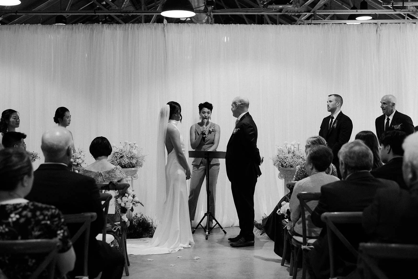 A black and white photo of a wedding ceremony taking place at garage B