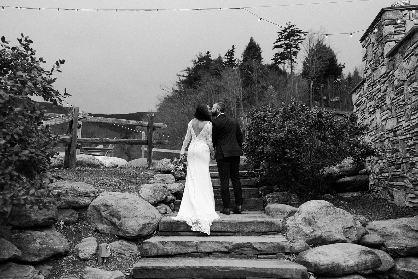 A couple kissing while walking through their Vermont wedding venue
