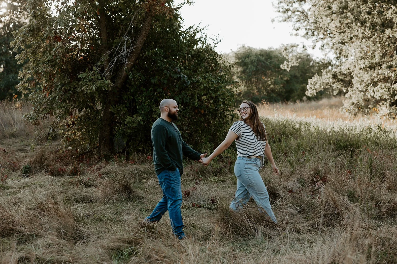 A couple walking in engagement photos at a Massachusetts engagement photo location, Rock MEadow