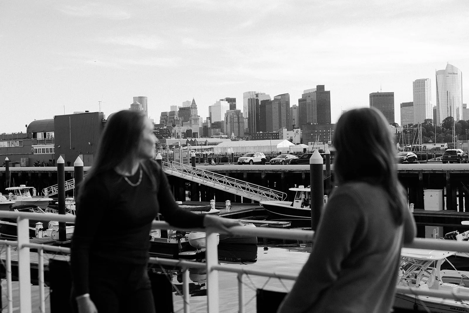 A black and white photo of a couple looking at the view from their Massachusetts engagement photo location