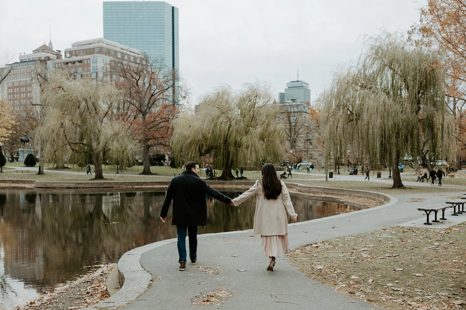 A couple walking holding hands in Boston Public Garden