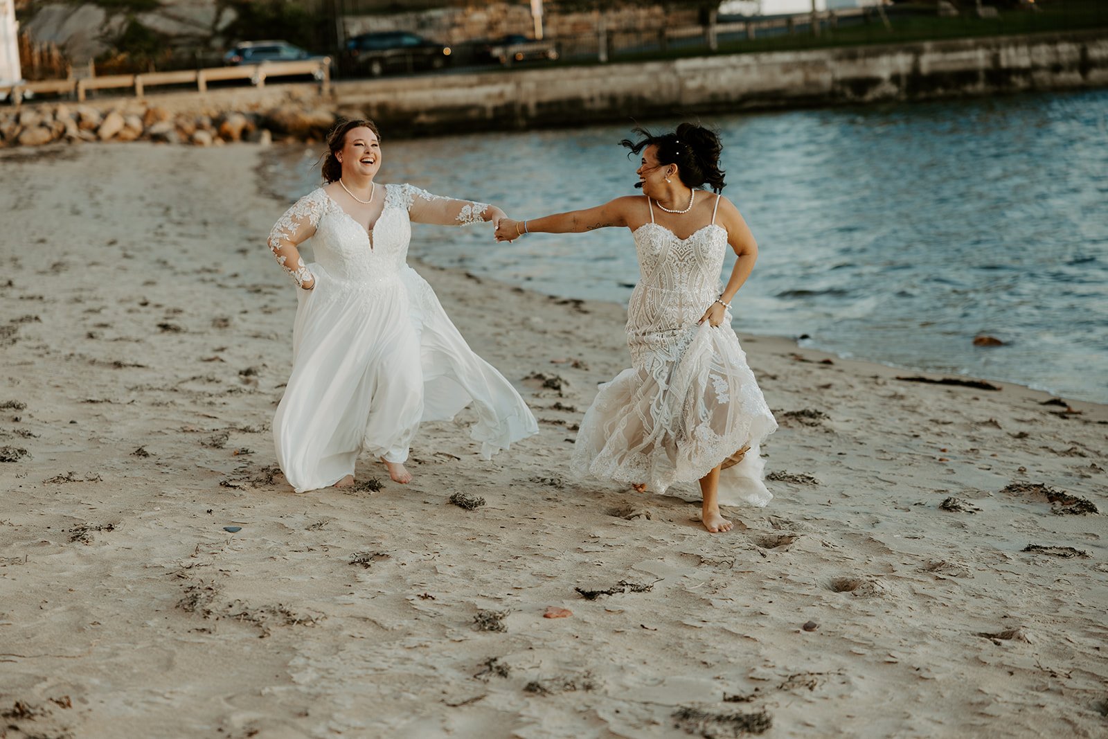 Two brides running on the beach for their wedding photos