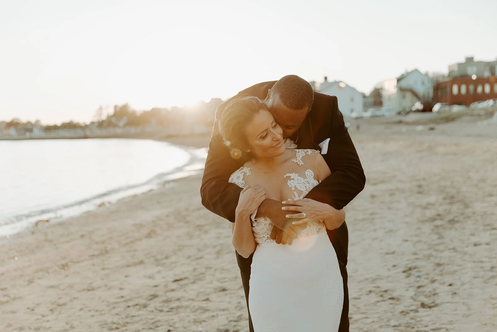 A bride and groom taking wedding photos on the beach