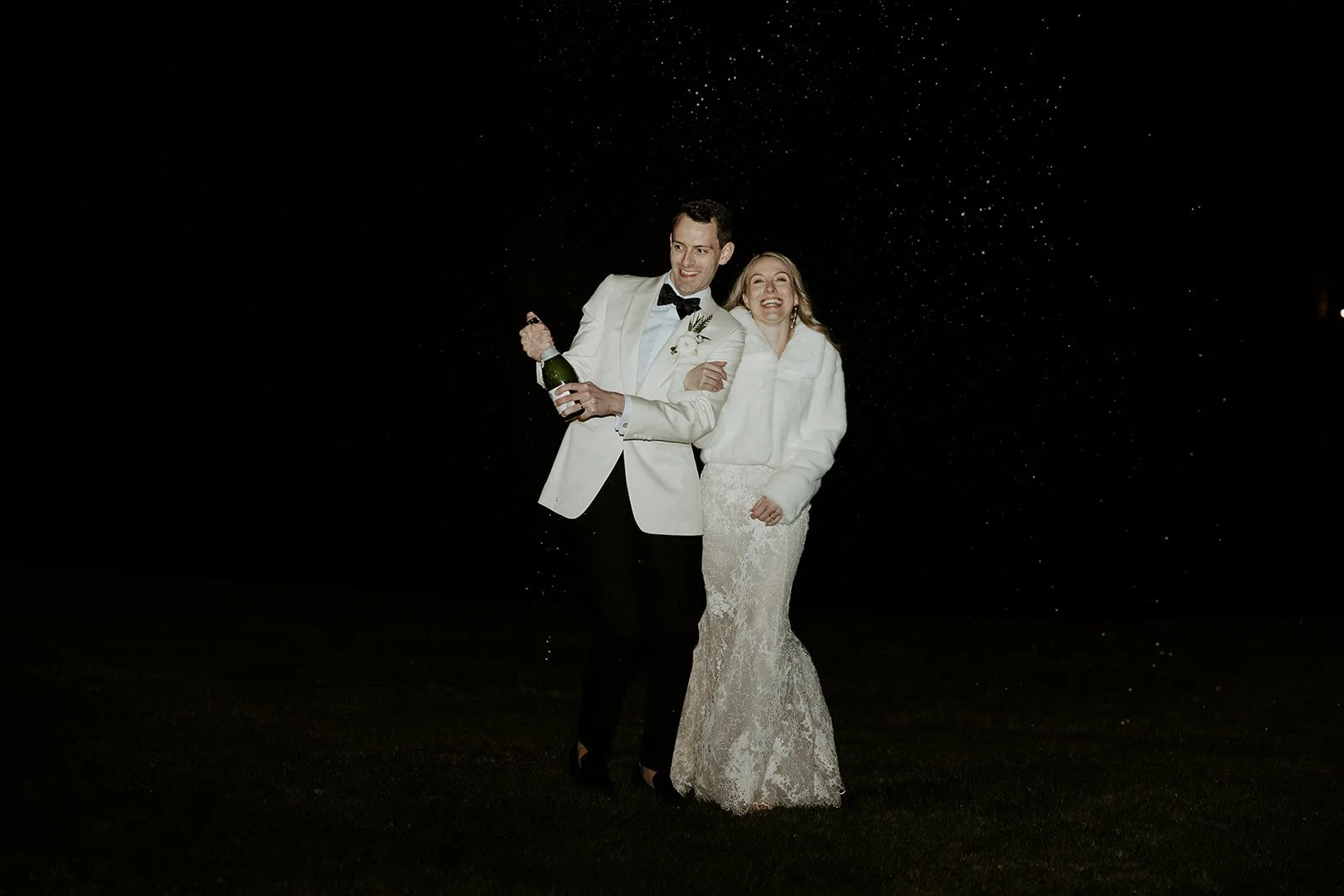 A bride and groom popping champagne