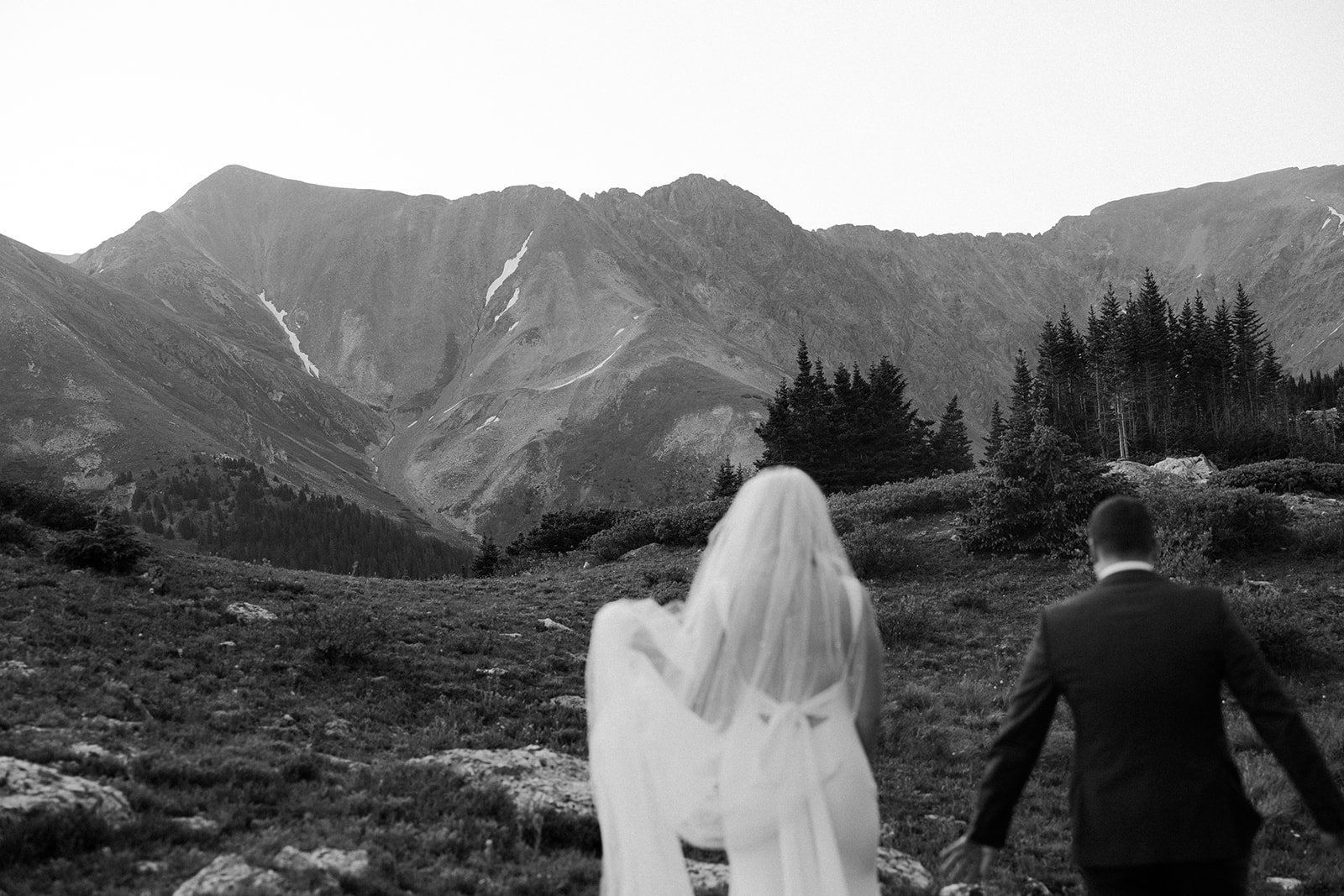 A bride and groom taking mountain destination wedding photos