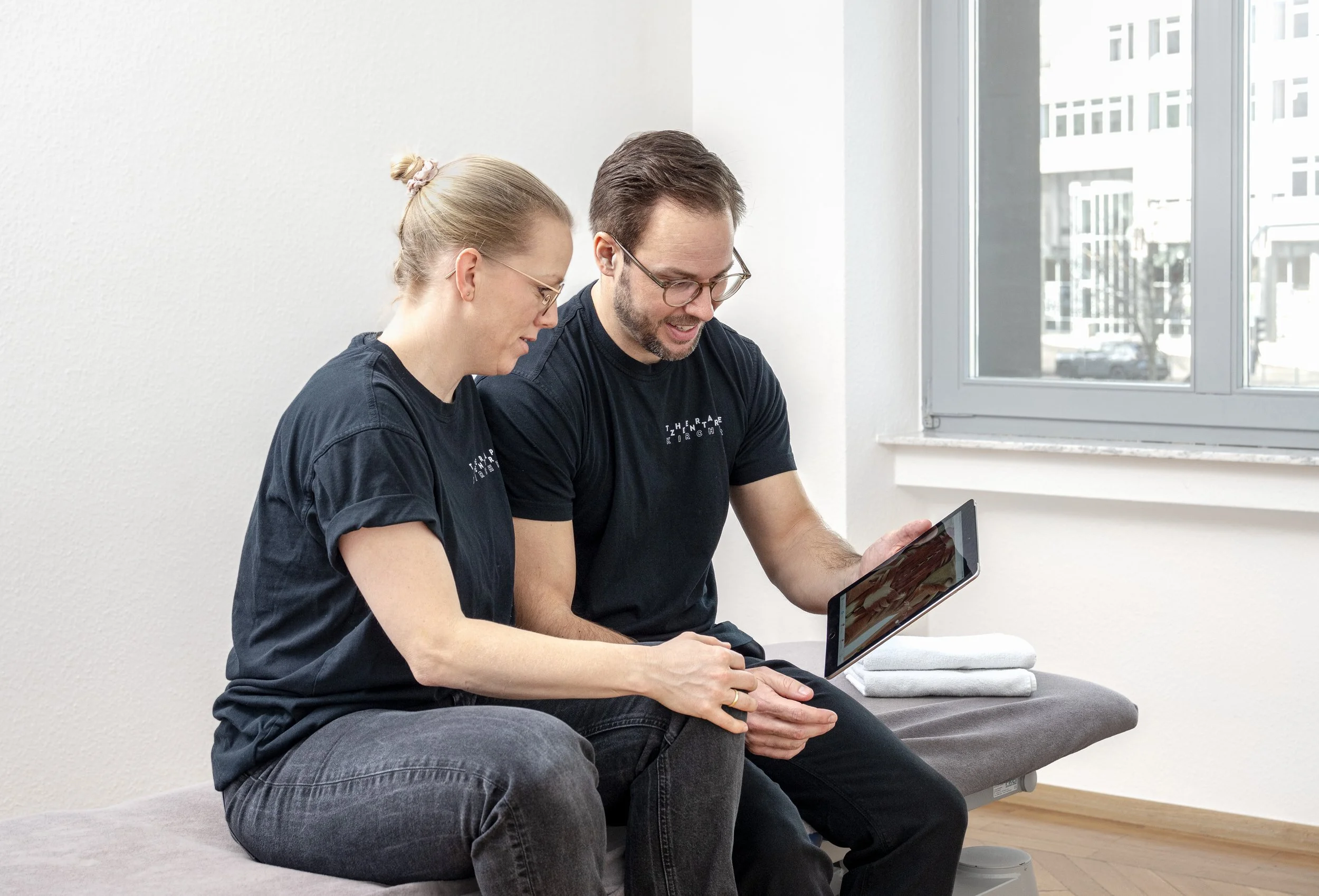 Physiotherapeuten planen Therapie mit Tablet im Therapiezentrum Kirchner Stuttgart