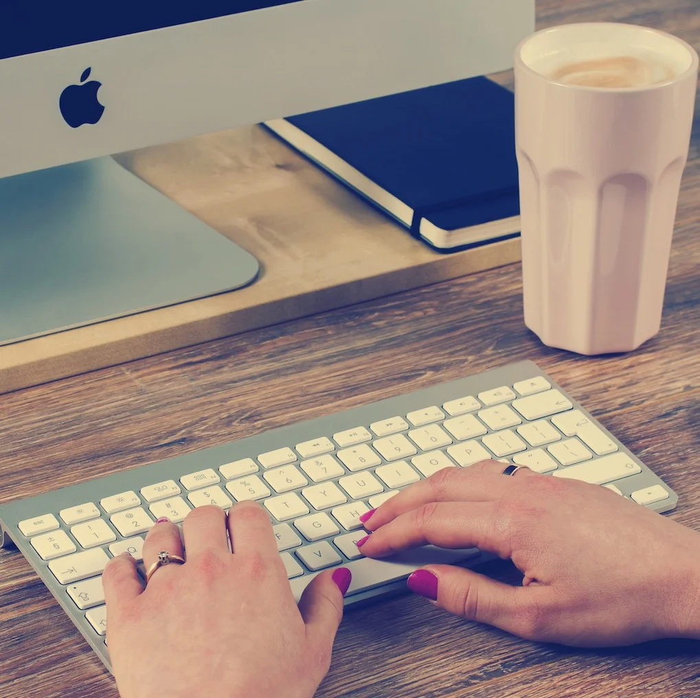 Hands of Female Custom Software Developer on Apple Keyboard