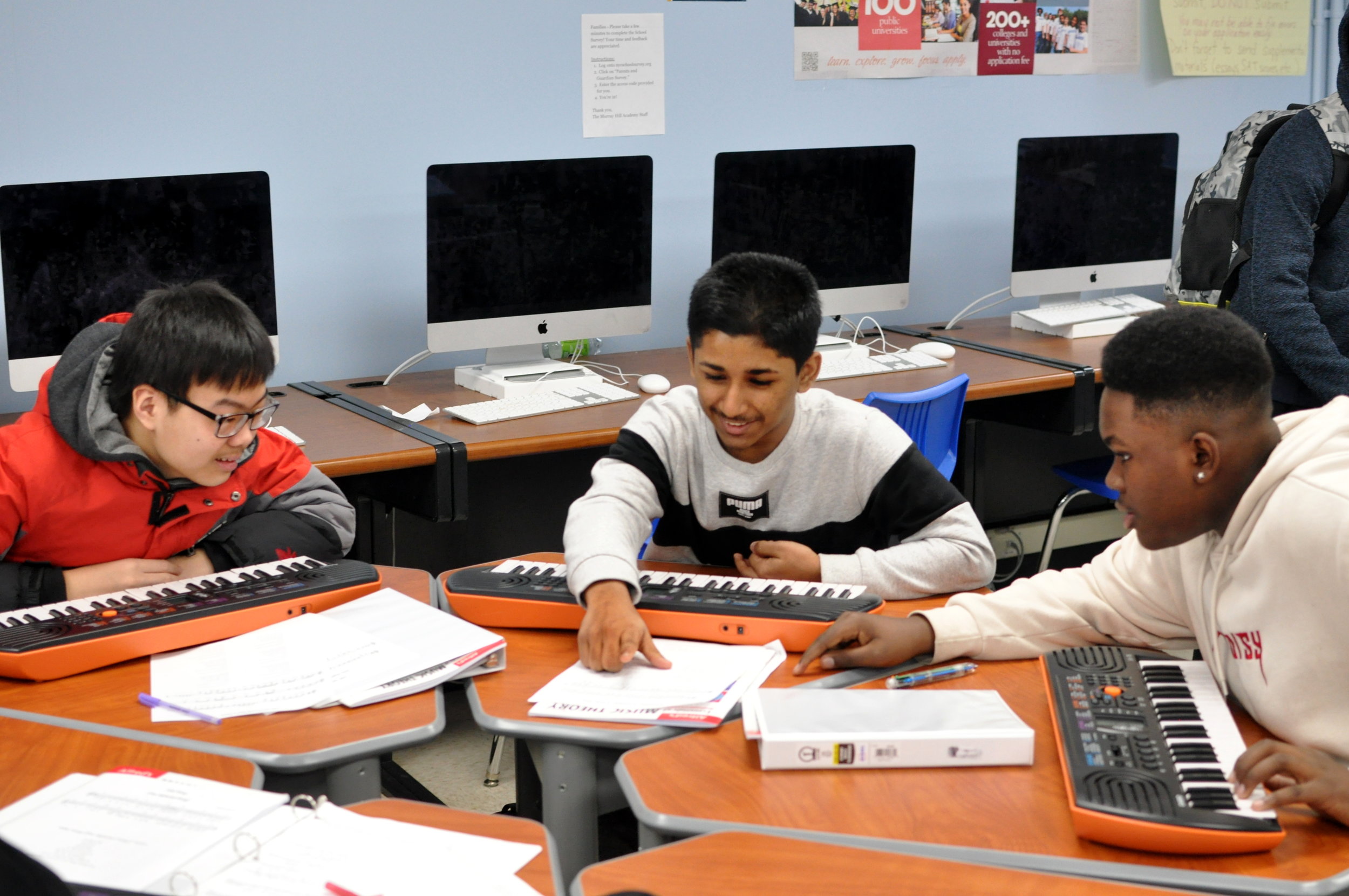 three students playing keyboard instruments