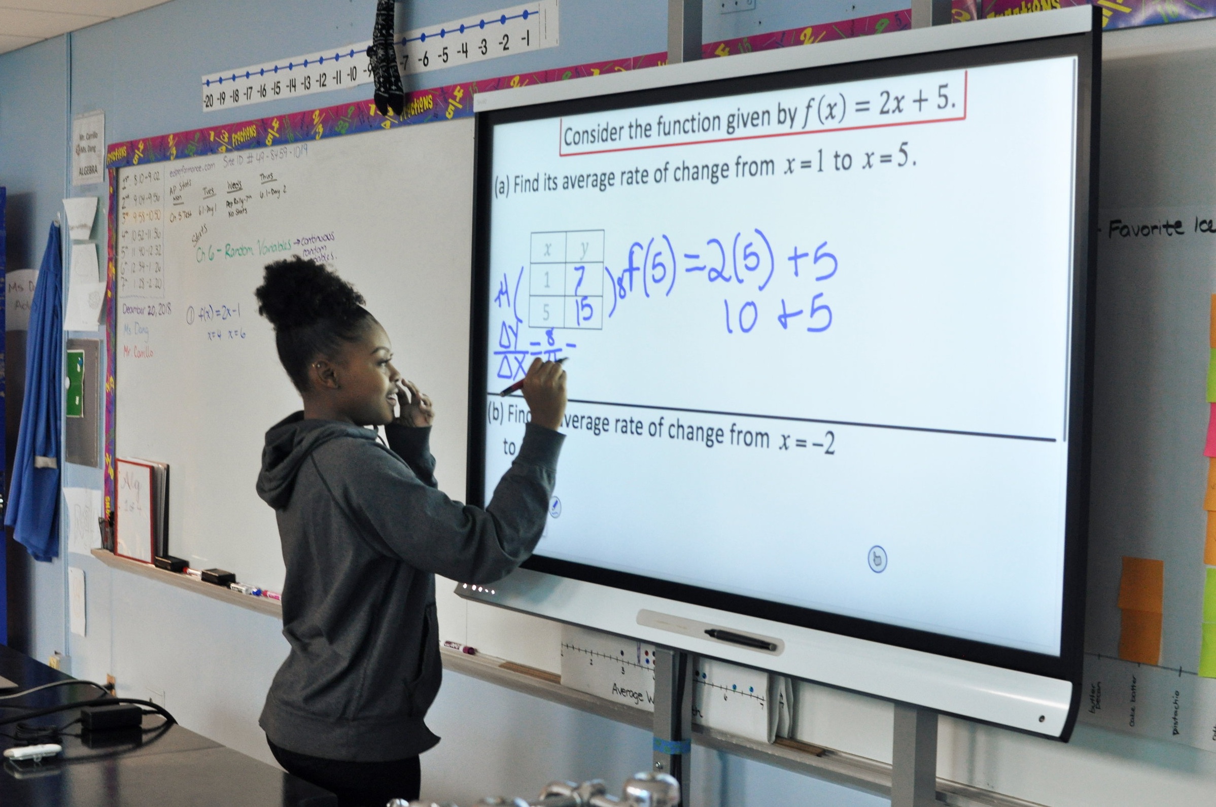 student uses smart board to work on math problem