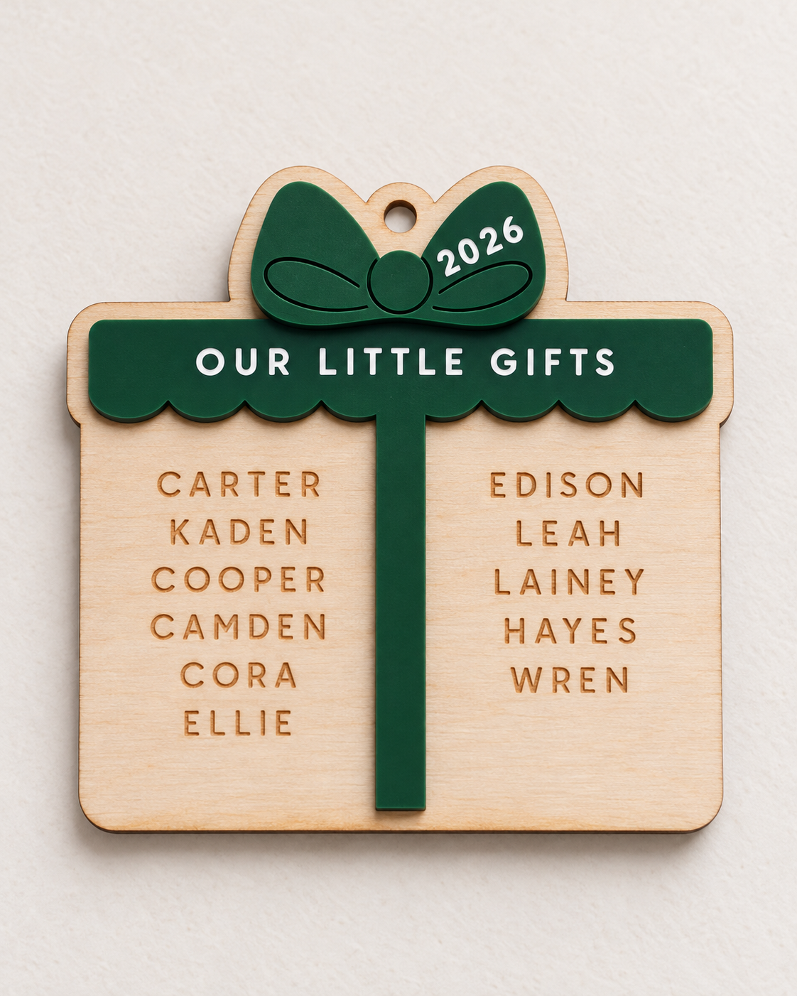 Personalized birch wood Little Gifts Christmas ornament with hunter green acrylic bow, engraved family names and 2026 detail