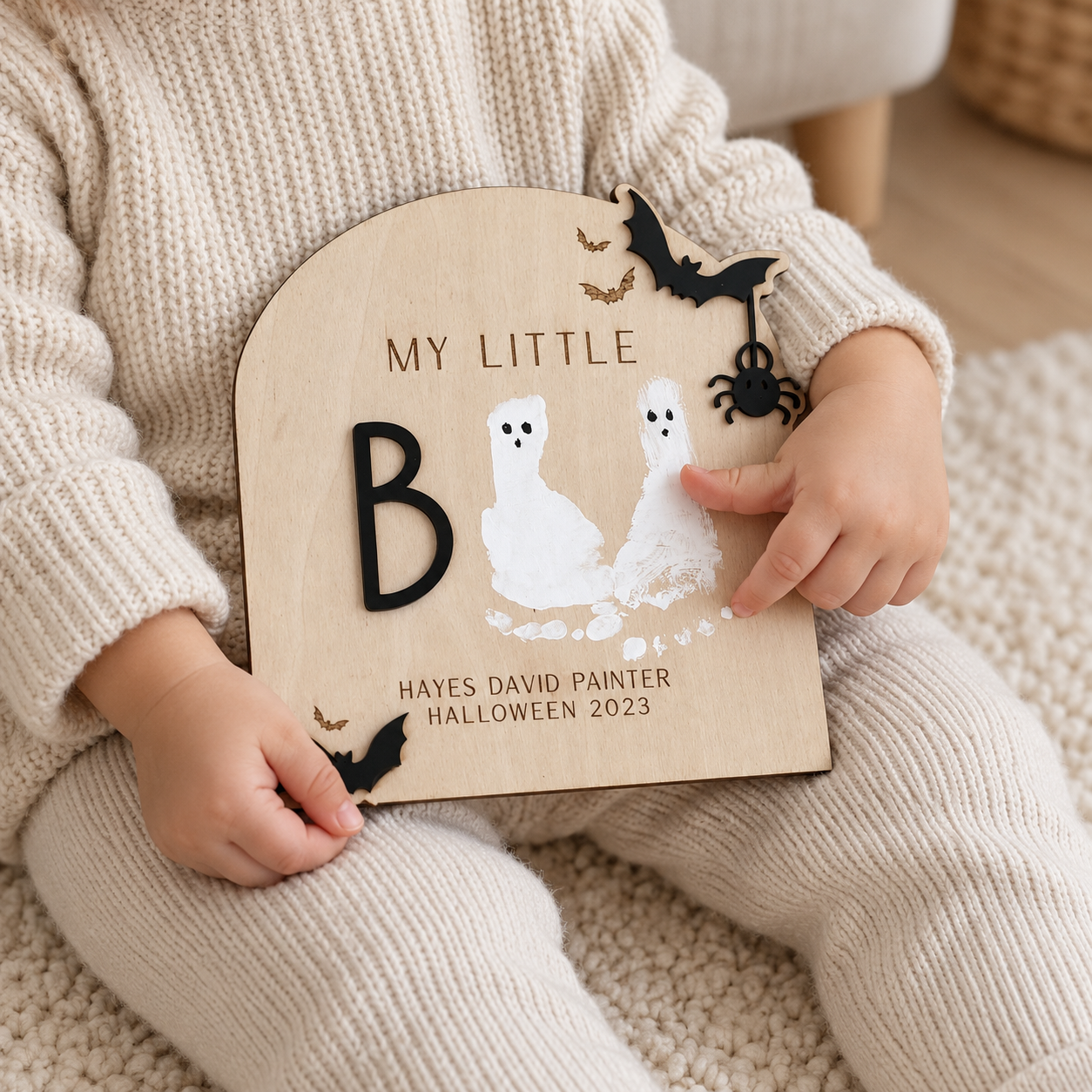 Toddler holding a wooden little Boo Halloween keepsake
