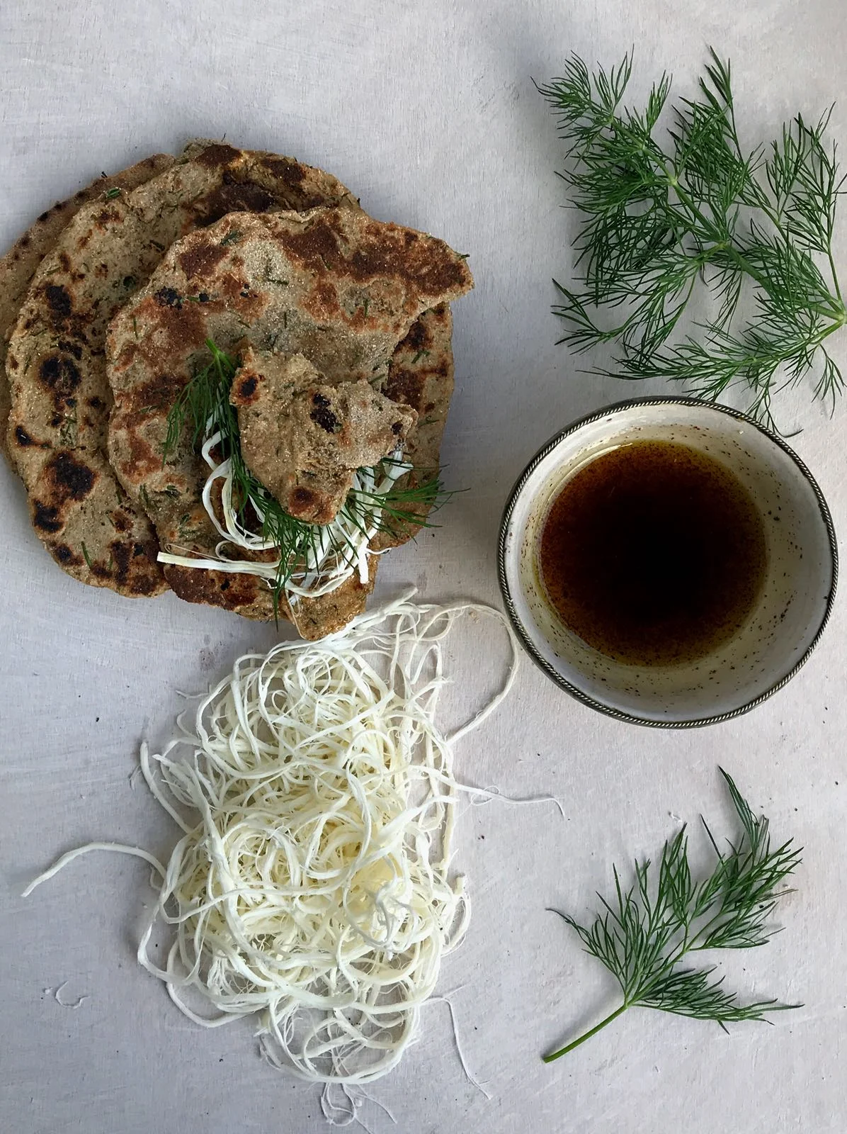 Barley semolina flatbread with dill,  sumac oil, and white string cheese