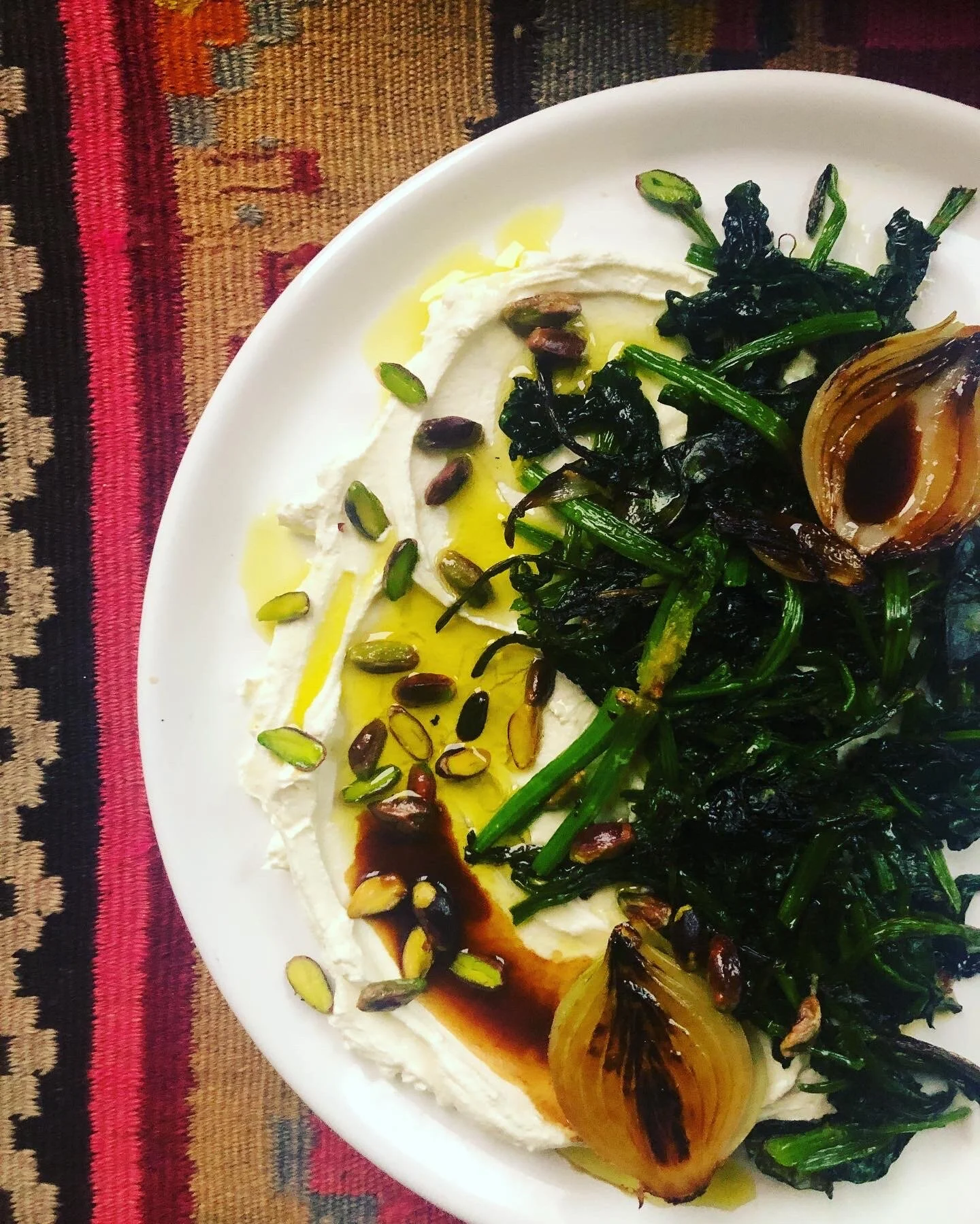 Labneh with garlicky spinach, baked onions, pomegranate molasses and pistachio