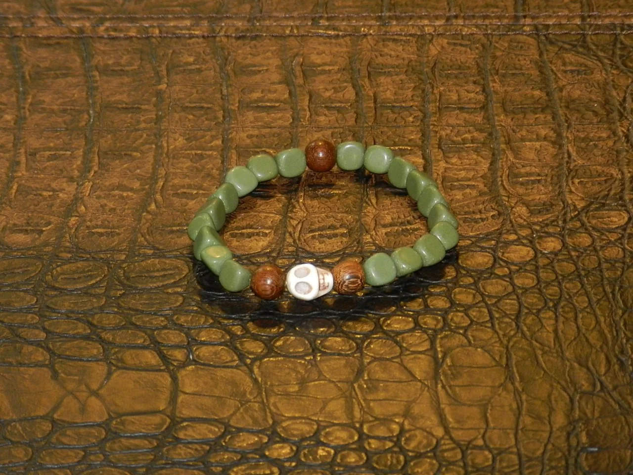 Handmade with Polished Green River Rocks, 10mm Malaysian Wood, anchoring a Howlite Skull.  Fits Wrists Size: 7.5” - 8”