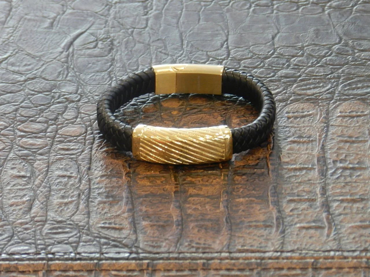 Men's braided black leather bracelet featuring a stainless steel bar, Gold Filled for a unique personal look.   Fits Wrists Size: 7” - 7.5”