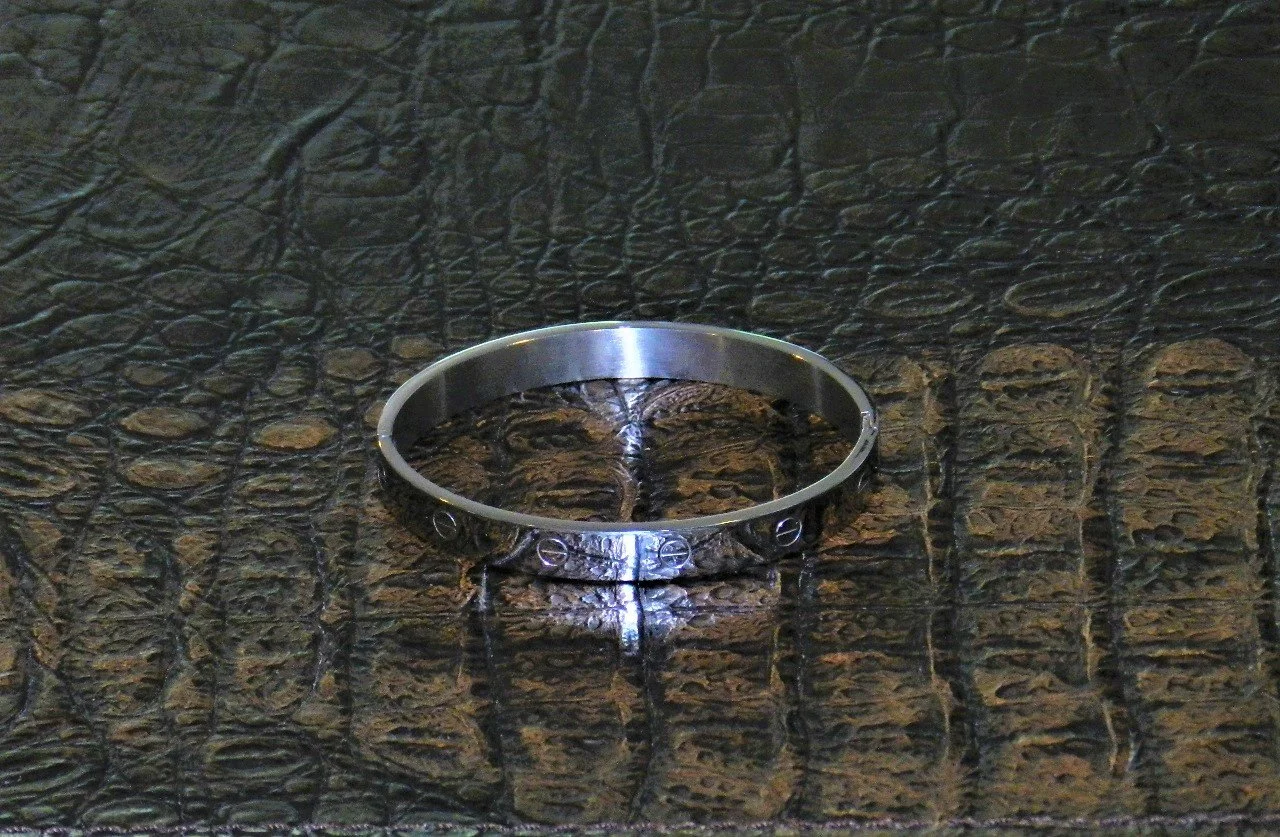 Our version of the Love Bracelet. Made of Stainless Steel with a snap-in-place locking system.  Fits Wrists Size: 6.5” - 7”