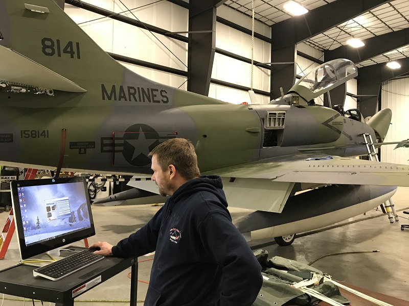 mechanic uses computer for aircraft maintenance