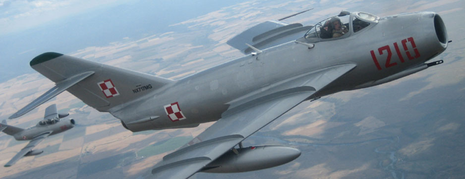 Mikoyan-Gurevich MiG-17 flying over field with MiG 15