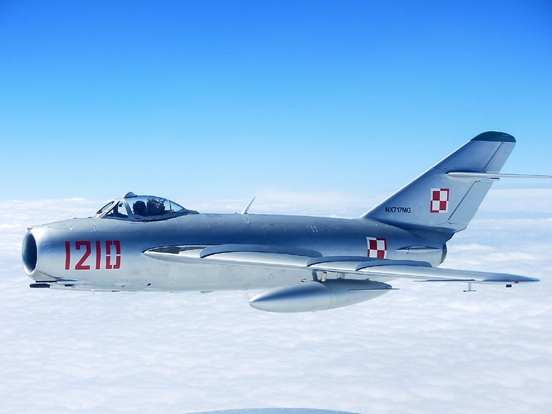Mikoyan-Gurevich MiG-17 flying in blue sky with clouds