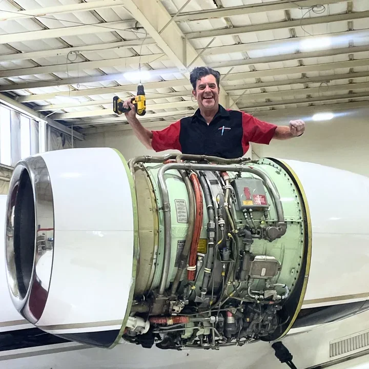 Technician servicing a Learjet engine