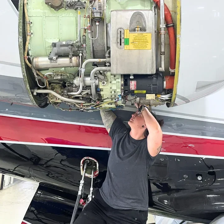 Technician removing an engine cowl on a stand
