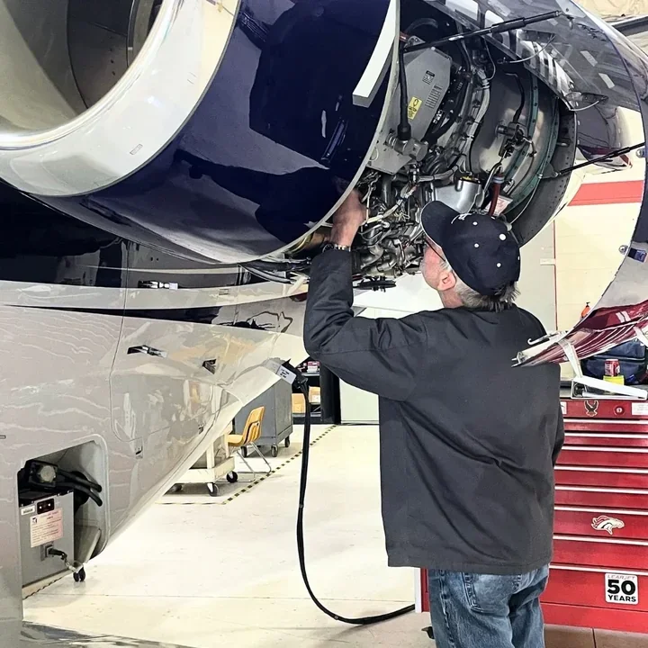 Technician inspecting an engine with a headlamp