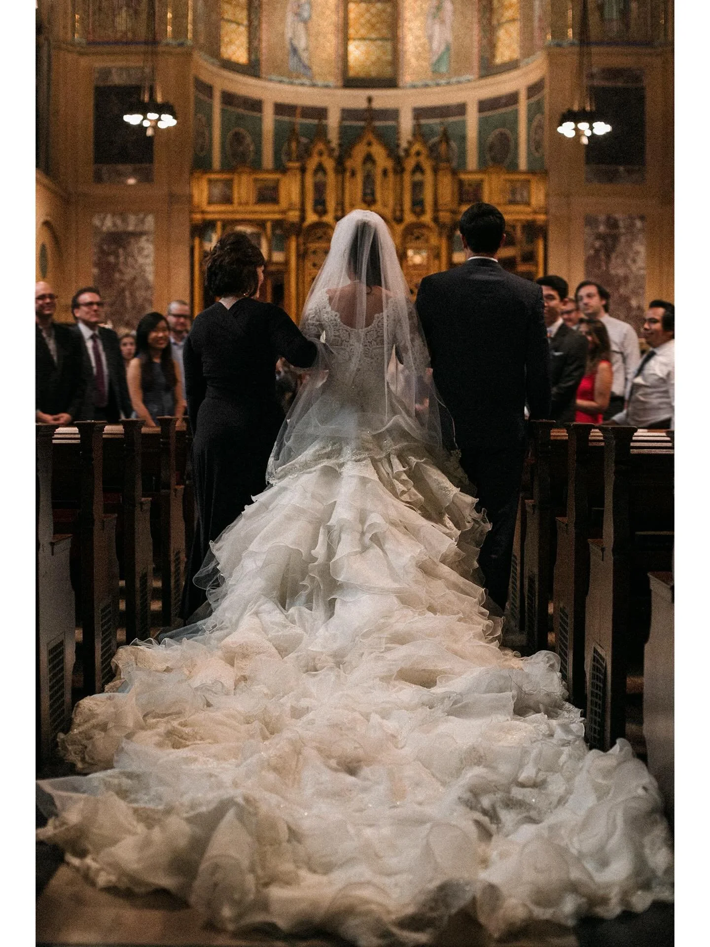 wedding snap low-angle shot captured from behind a bride as she is escorted down the aisle of a grand, ornate church cathedral-length wedding dress

#nycweddingphotographer #nycelopementphotographer #weddingdress