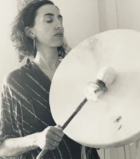 Femme avec cheveux bouclés, portant un kimono ou robe, tenant un instrument de peinture, un grand cercle blanc, dans un espace intérieur