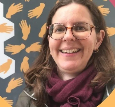 Femme souriante portant des lunettes, avec un fond de mains illustrant le concept de diversité ou d'entraide.