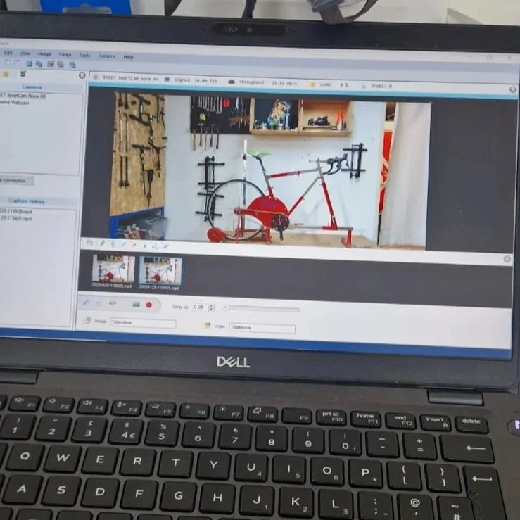 A computer screen displaying a photo editing software with a photo of a red bicycle and workshop tools in the background.