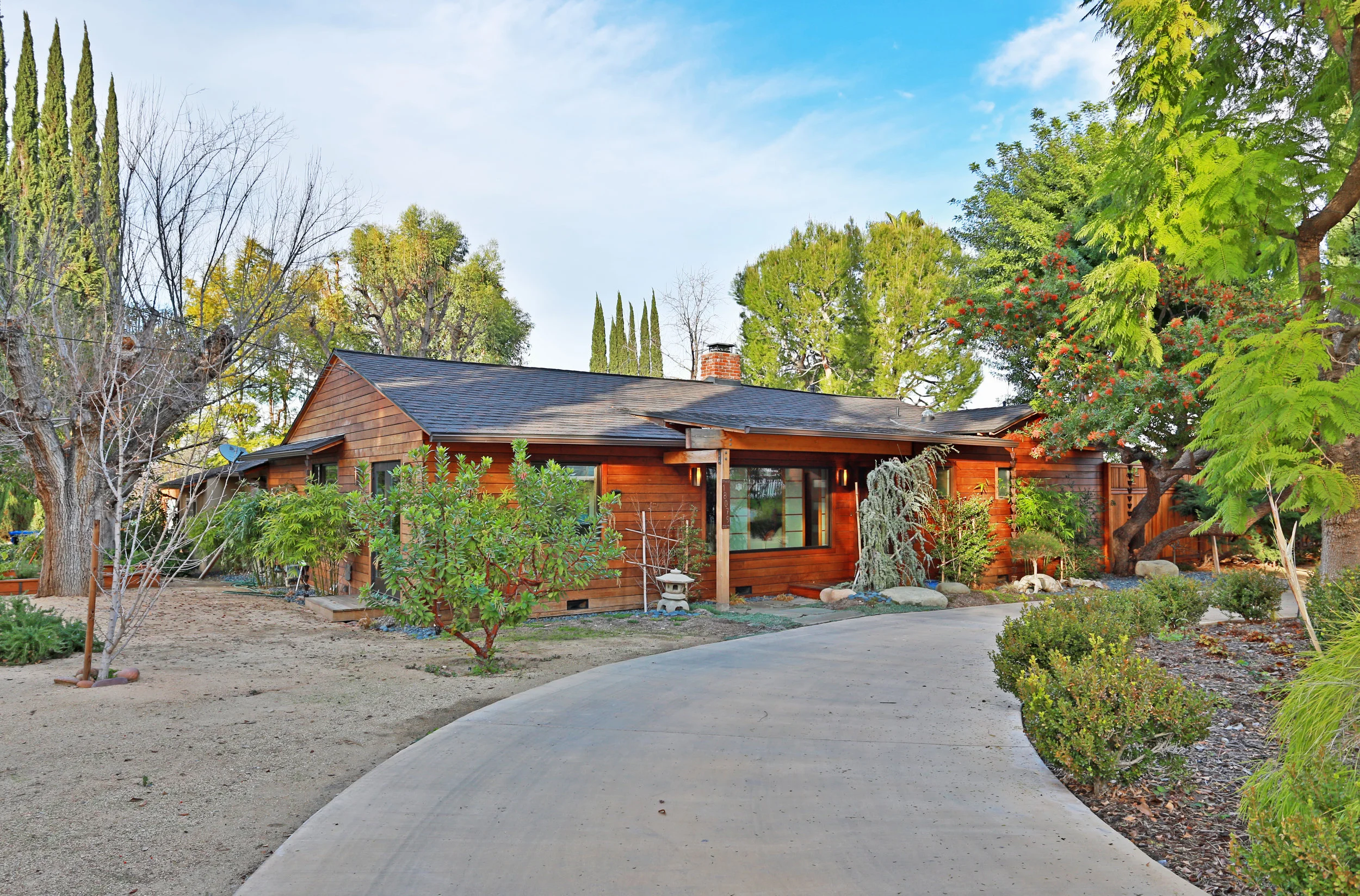 BURTON BRUMER REMODEL This house synthesizes our client’s preference for a Japanese styled Southern California Ranch. Located in the high-risk fire zone foothills of the Santa Monica Mountains, it utilizes thick Ipe fire-rated wood boards on much of the exterior cladding and decking. Walls were removed to create a large open Living Area containing both formal and informal sitting areas, a dining room and a kitchen. A large glazed “dormer” above the rear sitting area expands the space and brings in northern natural light. Sliding glass doors in the Master Bedroom and open the house to the newly landscaped rear yard. Tarzana, CA