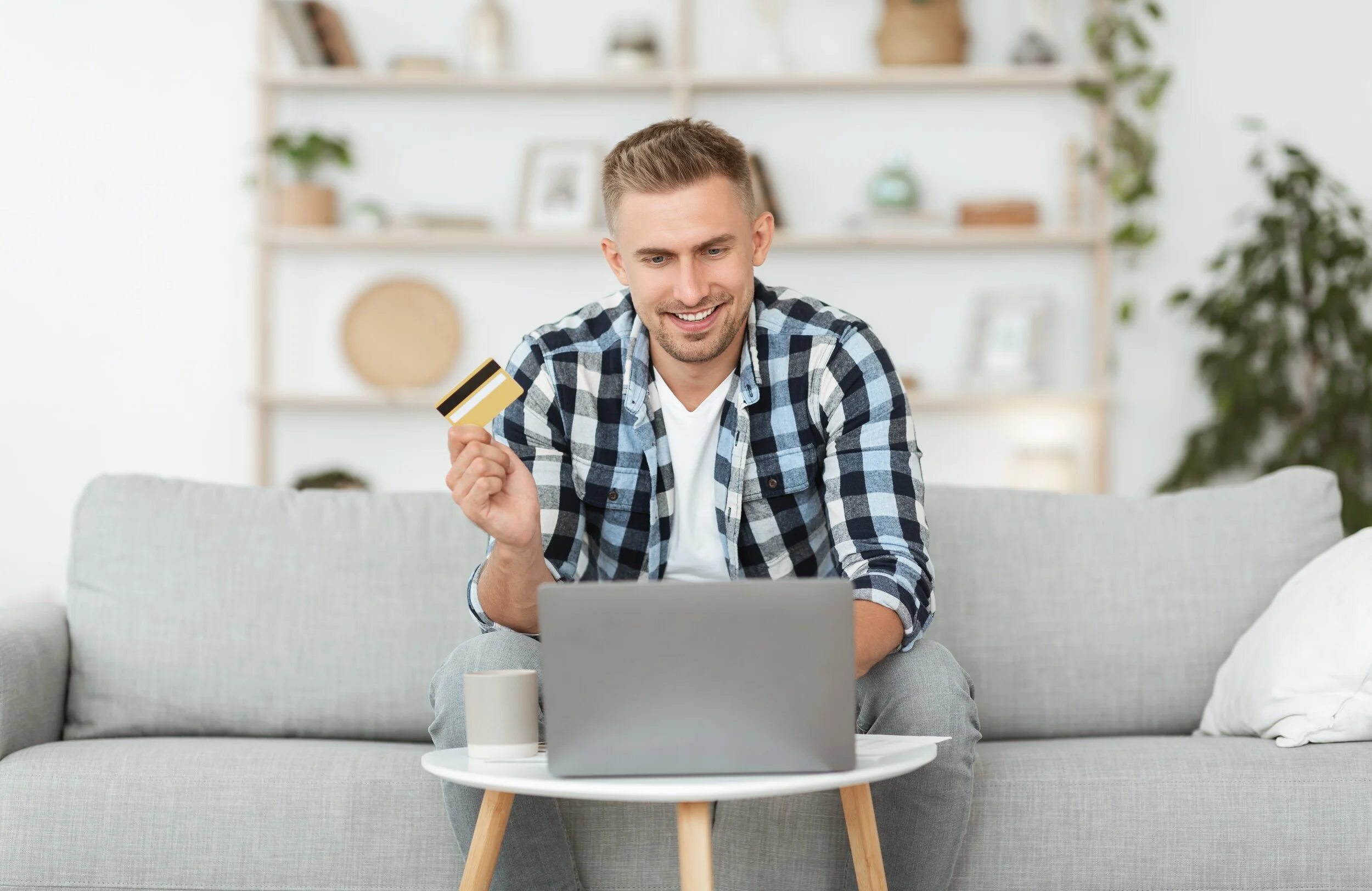 cheerful-adult-guy-using-laptop-and-credit-card-RQKYPRW-min.jpg