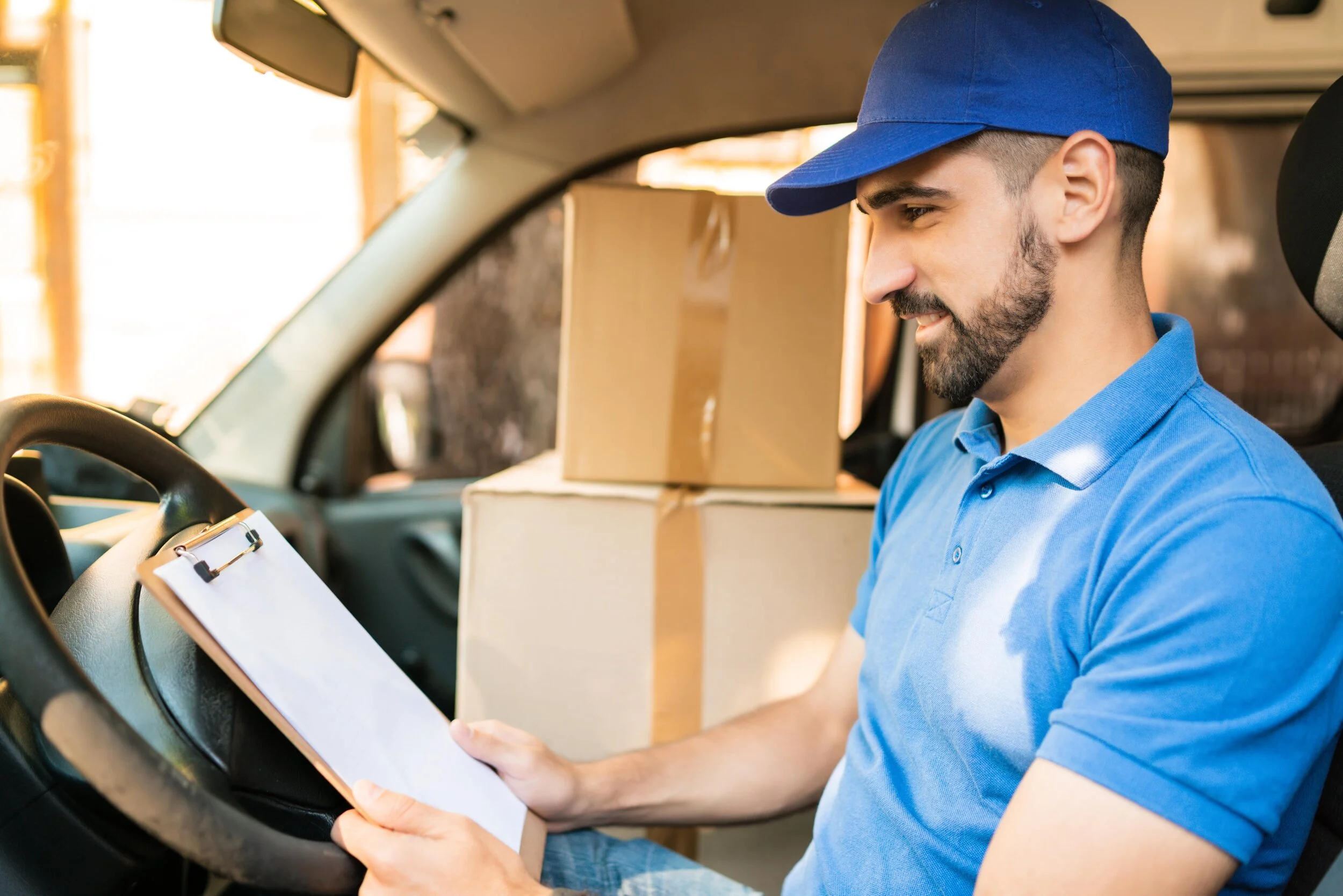 delivery-man-checking-delivery-list-in-van-G5ZKXL2-min.JPG