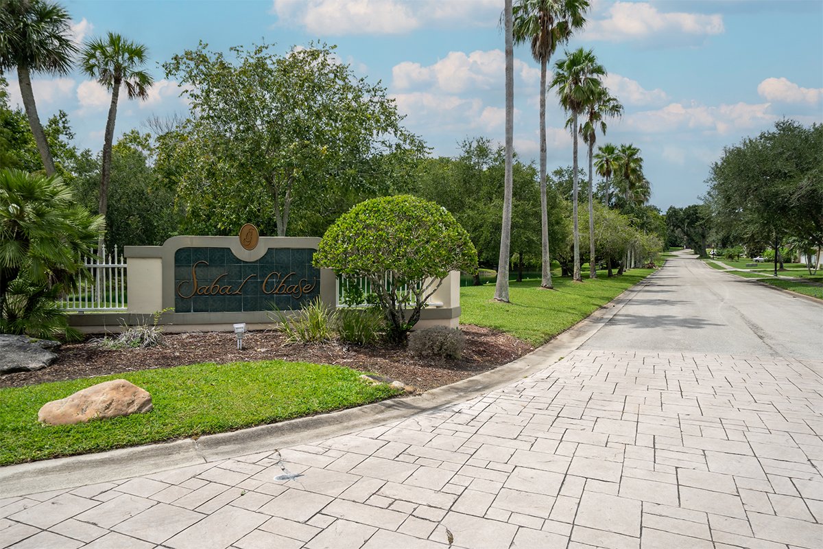 Entrance sign at Sabal Chase neighborhood lined with palm trees in Cocoa, Florida