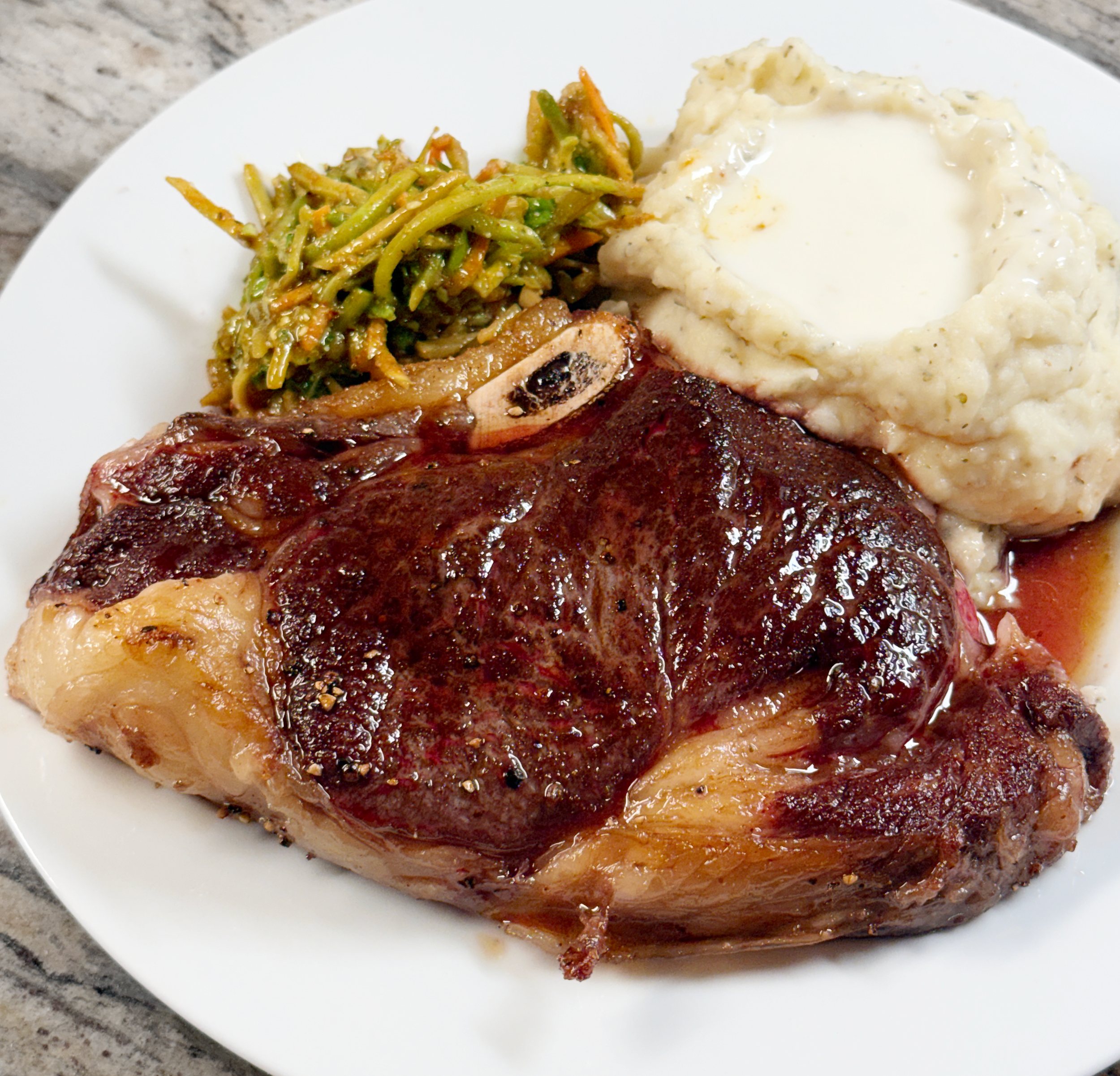 Plated seared boneless grass-fed ribeye with mashed potatoes and slaw.png