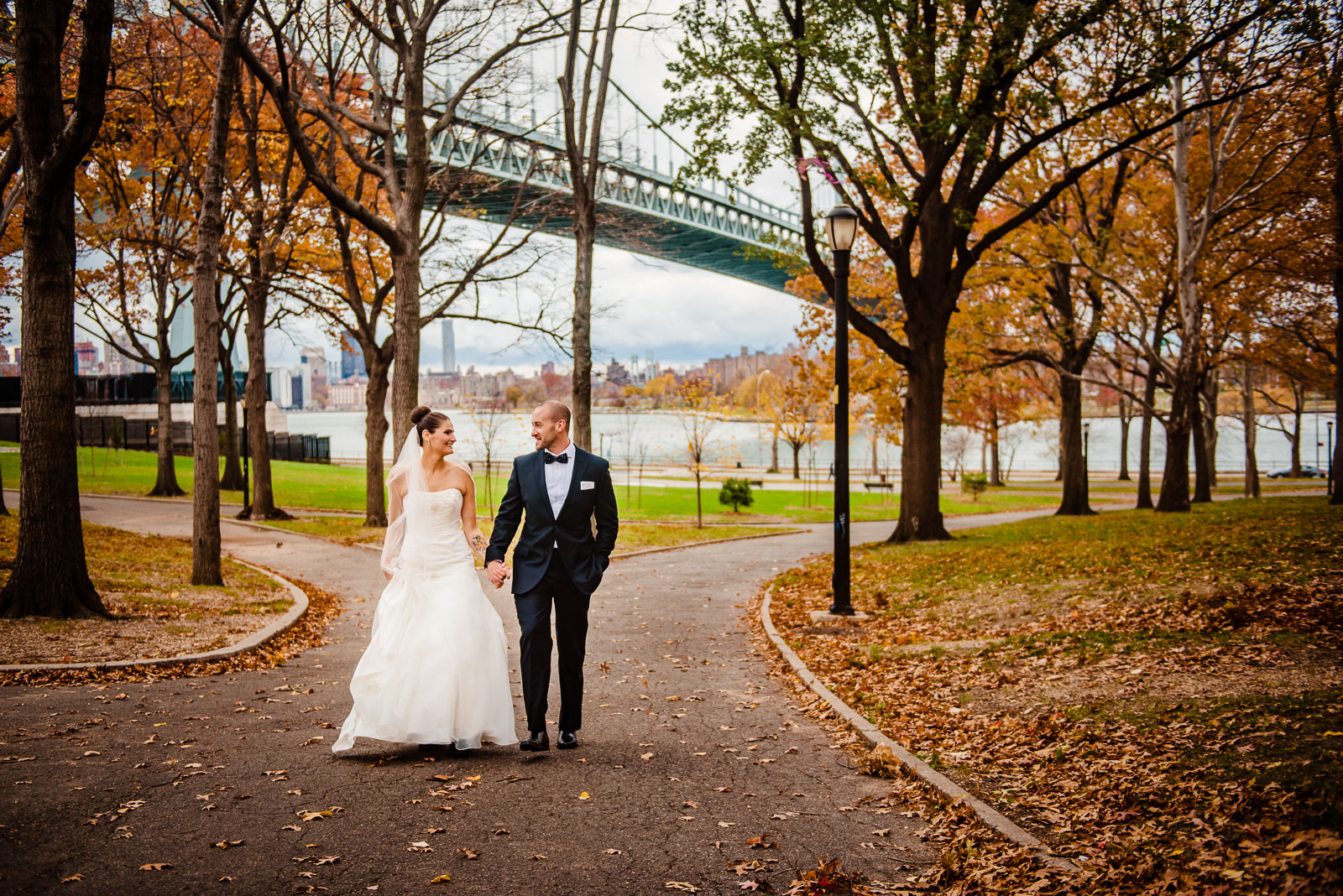  Bride's and groom walking in Astoria Park in Queens 