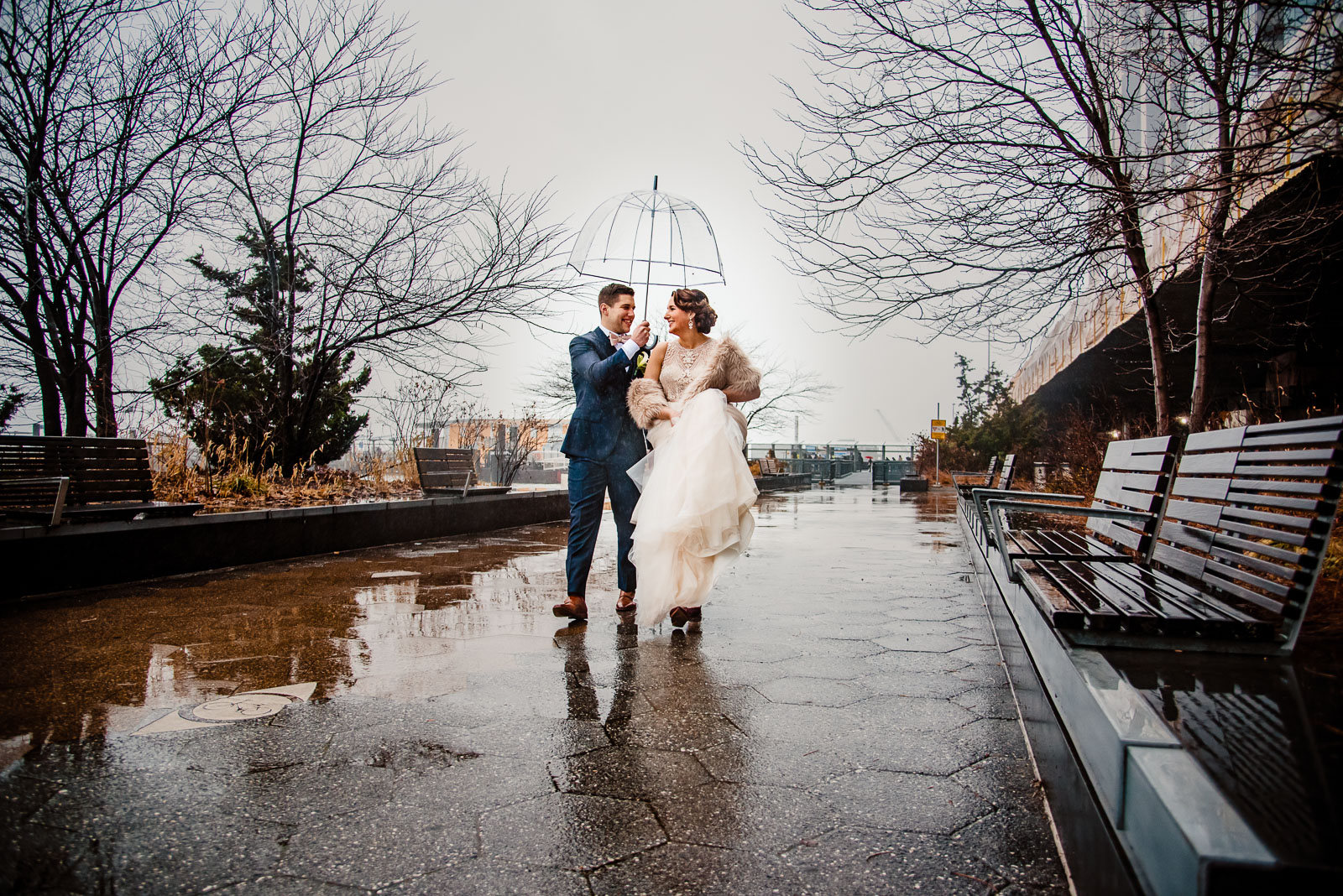 Bride an groom stroll in the rain 
