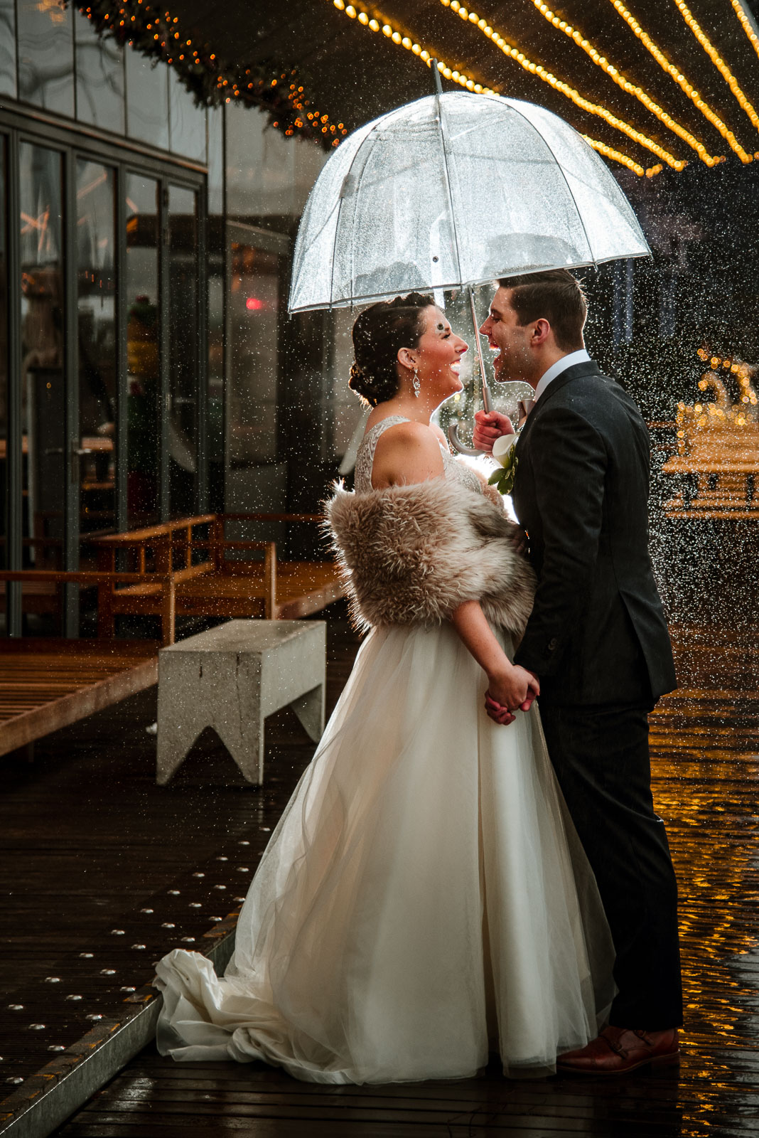 Bride and groom portrait in the rain with umbrella