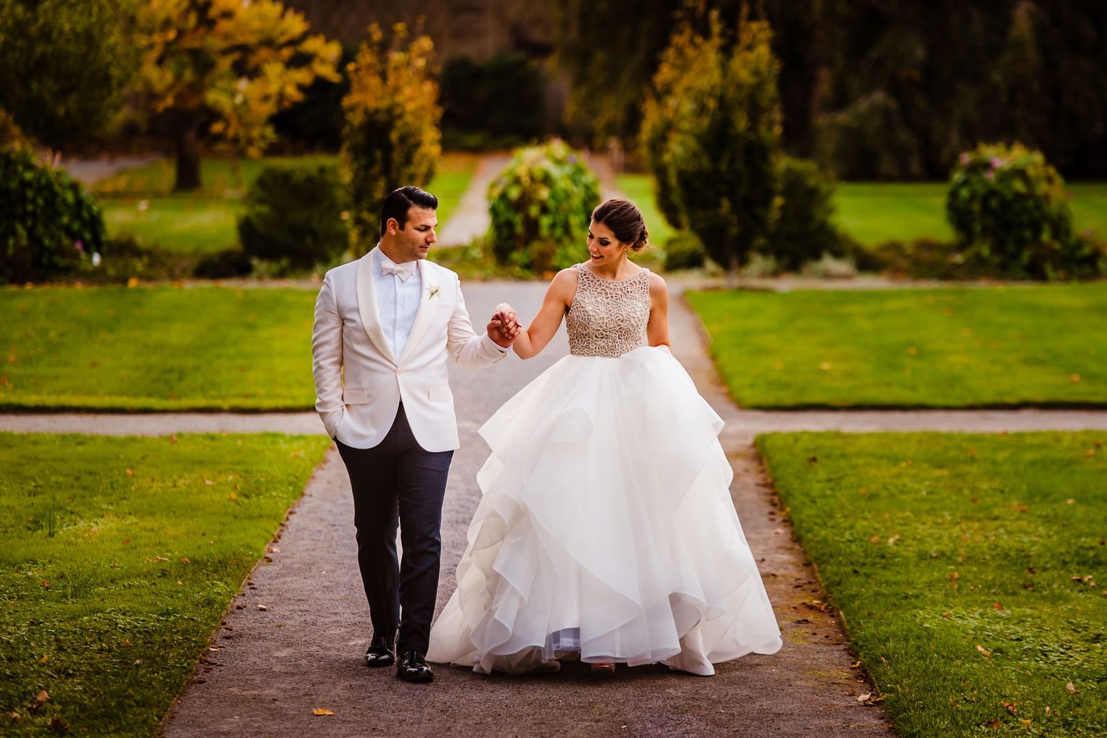 Bride and groom walk in park