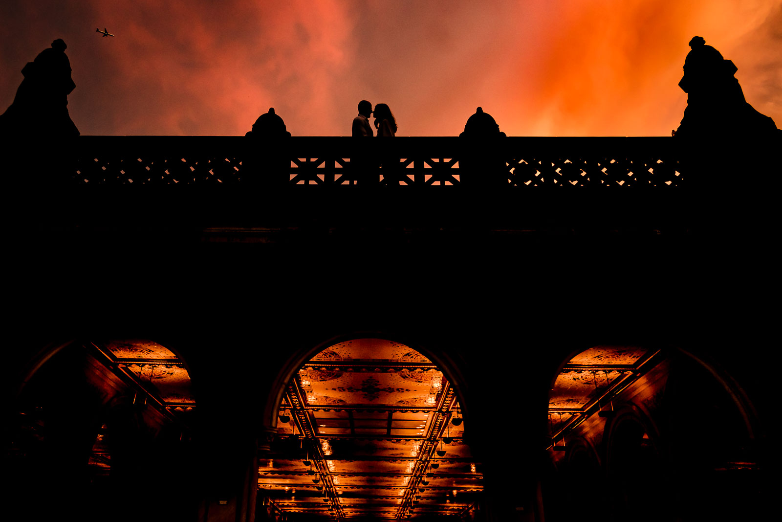 Couple silhouette with orange-red sunset at bethesda terrace in Central Park 