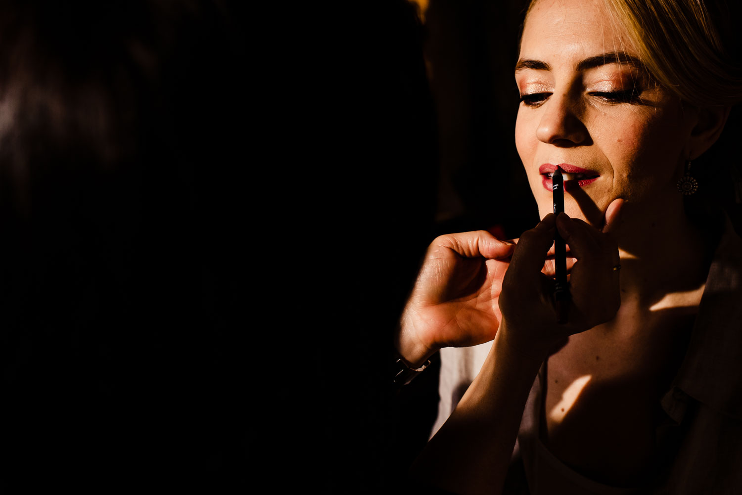 Bride applies red lipstick