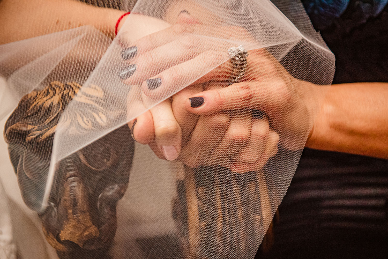 Bride and mother hold hands