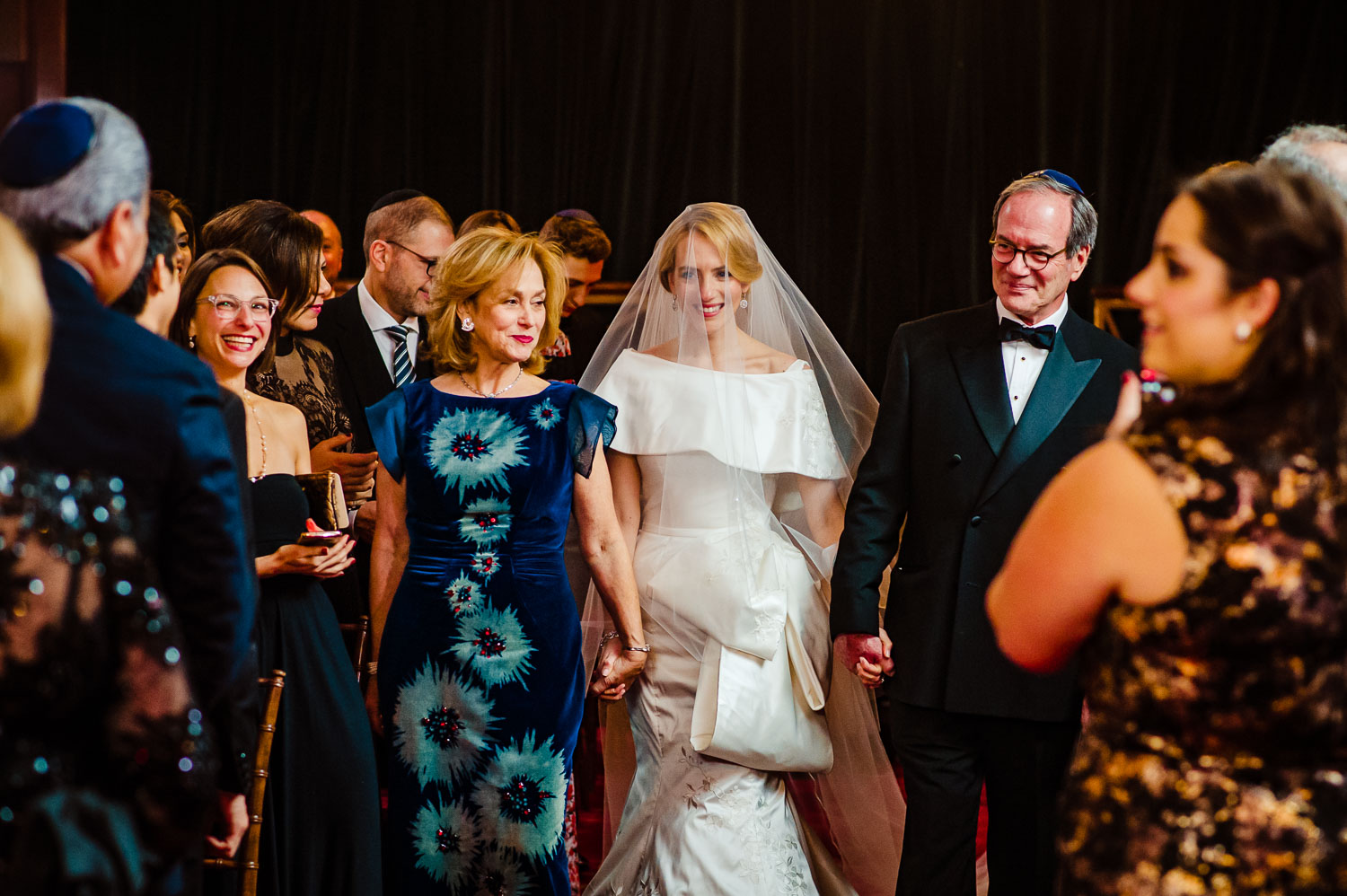 Bride and her parene walk down the aisle  